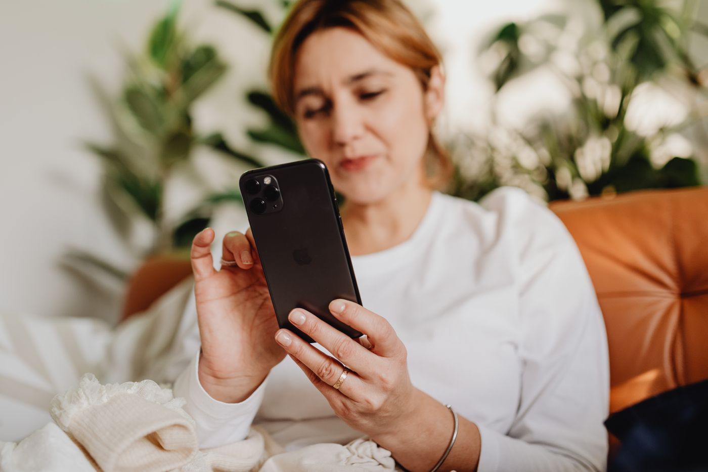 Paciente revisando su celular en casa